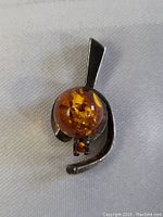 Front view of the vintage sterling silver pendant with large amber stone and smaller amber accent