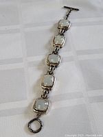 Full view of the sterling silver bracelet showing all five moonstone cabochons and the toggle clasp.