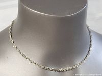 Front view of the sterling silver interlinked chain necklace displayed on a mannequin bust.