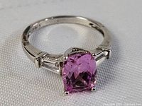 Close-up of the ring showing the pink topaz center stone, baguette accents, and sterling silver band.