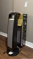 Heater placed beside its original box showing overall height and condition.