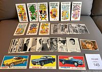 Lot of 40 1960s non-sport cards laid out on couch, showing Valentine greeting cards, black and white photographic cards, Beatles card, and sports car cards.