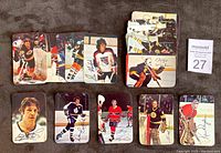 Photo showing fronts of a majority of the insert cards spread out on a surface displaying action shots of players and facsimile autographs. Cards show player mid-game in team uniforms, some skating, some posing.