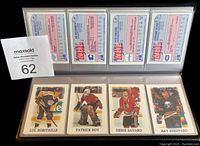 Hockey cards in plastic sleeves including Luc Robitaille, Patrick Roy, Denis Savard, Ray Sheppard with backs visible.