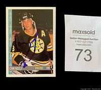 Close-up image of Cam Neely autographed hockey card in Boston Bruins uniform with Sharpie signature.