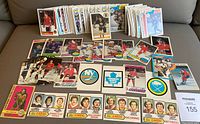 Collection of hockey player cards, team logos, and NHL leader stats cards from 1970s to 1980s arranged on surface