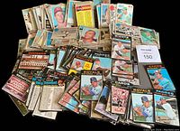 Wide view of many vintage baseball cards spread out with visible player images and teams such as Royals, Padres, Phillies, Expos.