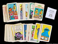 Photos showing complete set of vintage Sesame Street alphabet and numbers flash cards from 1978 featuring various character illustrations on colorful fronts and monochrome backs.