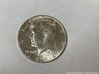 Obverse side of 1964 Kennedy Silver Half Dollar coin showing portrait of Kennedy and date.
