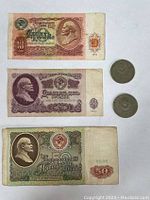 Image of front sides of the 10, 25 and 50 Rubles banknotes with two 1 Ruble coins beside them, showing portrait of Lenin on banknotes.