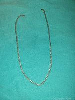 Full view of the 23 inch silver chain necklace laid flat, showing entire length and condition.