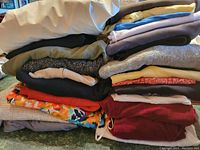 Stack of assorted folded ladies' medium size clothing in various colors and patterns.