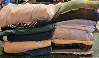 Stack of folded men's clothing in assorted colors and fabrics.