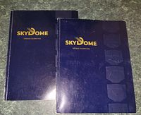 Two hardcover Skydome books side by side showing front covers with gold lettering on blue background.