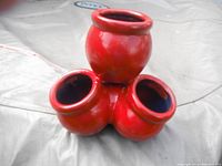 Red funky flower pot showing three smaller pots at base and one large pot at top, glossy red finish.