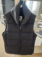 Front view of black Old Navy ladies puffer vest on a hanger.