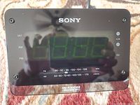 Close-up top view of black Sony Dream Machine digital alarm clock radio showing clear green LED digits and AM/FM frequency bands.