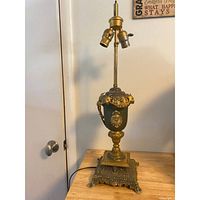 Full view of the French gold gilt metal urn lamp showing the urn shape, ram's head motifs, and ornate base.