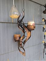 Full view of vintage copper hanging lantern with two candles on holders, showing twisted design and patina.