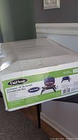Box showing UniFlame brand with product image and specifications, highlighting the deep cobalt 18-inch portable gas grill.