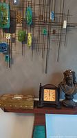 Shelf display with gold gilt tissue box, Seth Thomas mantel clock, and Jesus bust statue