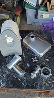 Weston electric meat grinder main unit with disassembled attachments on black marble surface.