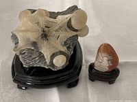 Front view showing larger spider web stone sculpture and smaller dragon stone sculpture on stands