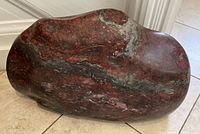 Front profile of the polished bloodstone rock on tile floor.