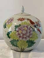 Full front view of the round hand-painted porcelain ginger jar showcasing vibrant floral and bird design.