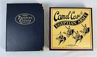 Two closed boxed sets side by side: navy ‘Trooping the Colour’ box with gold corners and yellow/red ‘Camel Corps Egyptian Army’ box