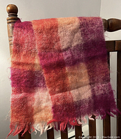 Full view of the vintage mohair scarf draped on chair showing color block pattern and fringed ends.