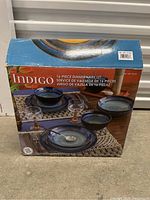 Box of Indigo 16-piece dinnerware set showing product image and branding on front.