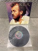 Vinyl LP record displayed in front of the album cover with a portrait of Joe Cocker in profile.