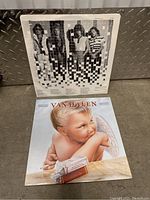 Two Van Halen vinyl record album covers, one featuring a baby angel and the other with the band members photo on the back cover.