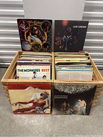 Wooden crates filled with vinyl records, featuring albums by Joe Cocker, Cream, The Monkees, and others