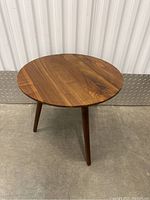 Round wood side table top and surface showing natural wood grain.