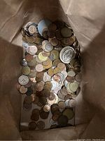 View inside a bag containing numerous assorted world coins.