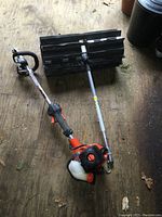 Full view of engine powerhead with straight shaft and detached paddle sweeper head