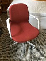 Front and side view of IKEA office chair showing red fabric and white armrests.