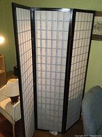 Full view of three-panel trifold room screen with black wooden frame and white translucent panels in a grid pattern.