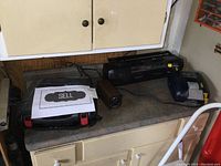 View of all four items on kitchen counter: Mastercraft electric sharpener, electric pencil sharpener, Sony portable radio with cassette, Skil cordless drill without battery or charger.