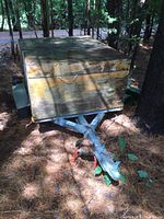 Front view of utility trailer with box showing wood paneling and metal frame hitch.