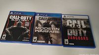 Three Call of Duty game cases laid flat on a white surface: PS4 Black Ops III, PS4 Modern Warfare, and PS5 Vanguard.