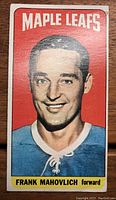 Front view of the hockey card showing Frank Mahovlich in Maple Leafs jersey with red background and yellow name strip.
