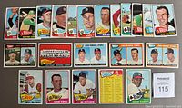Top view of 22 vintage 1965 Topps baseball cards arranged in rows, showing player images and a checklist card