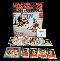 Full view of sticker album standing upright behind laid out stickers showing the near complete set and wax wrapper.