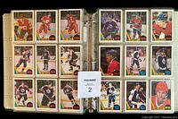 Two-page spread of hockey cards in protective binder sheets showing multiple player cards from the 1987-88 O.P.C. set.