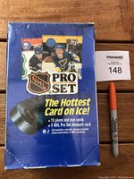 Front view of sealed blue box with NHL Pro Set logo, featuring hockey player images and product details about 15 photo/stat cards and 1 discount card per pack.