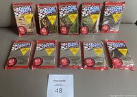 Ten unopened Soccer Shots foil wax packs from the 1991 Premier Edition lying on a table, showing various metallic pack colors and labels promoting the special Pelé card inside.