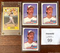 Close up photo showing one Barry Bonds baseball card in a protective case with three Randy Johnson rookie cards beside it, 1980s OPC series.